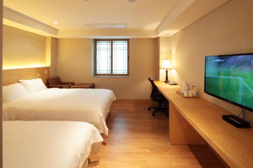 a hotel room with two beds and a flat screen tv at Dream House in Seoul