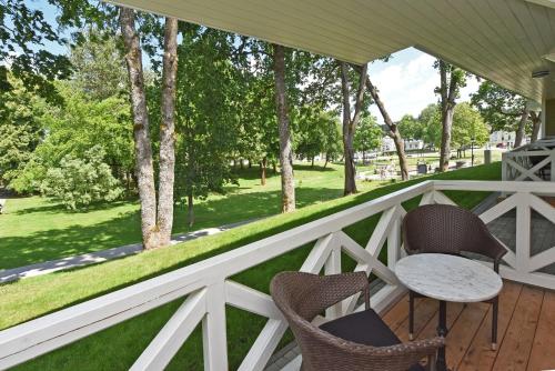 a white porch with chairs and a table on it at Vila Klasika in Birštonas