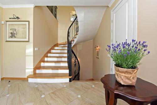 a staircase in a home with a vase of flowers on a table at Vila Klasika in Birštonas