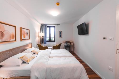 two beds in a room with white walls at Second Life in Piran - Hotel Zala Piran with private parking and shuttle service in Piran