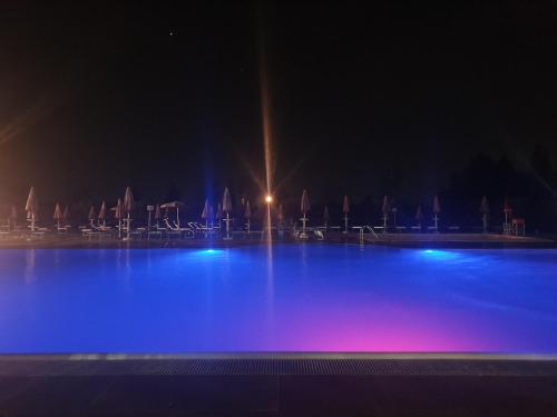 una gran piscina por la noche con luces azules en Locanda Corte Arcangeli, en Ferrara