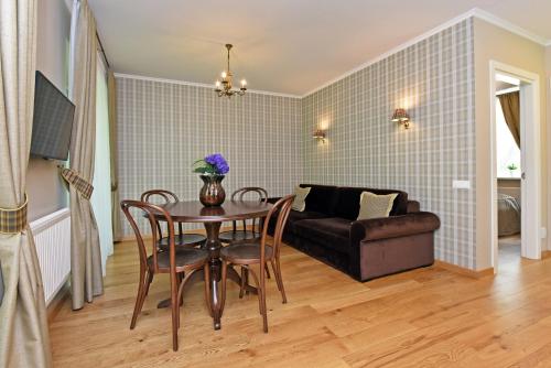 a living room with a table and chairs and a couch at Vila Klasika in Birštonas