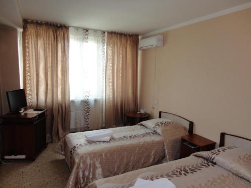 Habitación de hotel con 2 camas y ventana en Hotel Druzhba, en Abakán