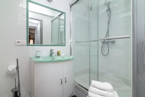 uma casa de banho com uma cabina de duche em vidro e um lavatório. em Appart' Vieil Antibes em Antibes
