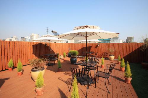 a patio with tables and chairs and an umbrella at Dream House in Seoul