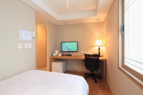 a bedroom with a bed and a desk with a computer at Dream House in Seoul