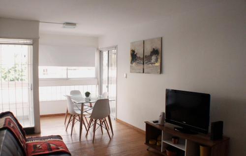 sala de estar con TV y mesa con sillas en Torre Augusta en Córdoba