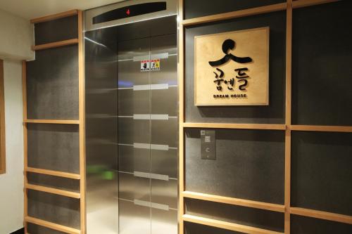 a glass elevator with a poster on the wall at Dream House in Seoul