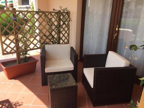 two chairs and a table on a balcony at ESMERALDA'S ROOMS in Porto San Paolo
