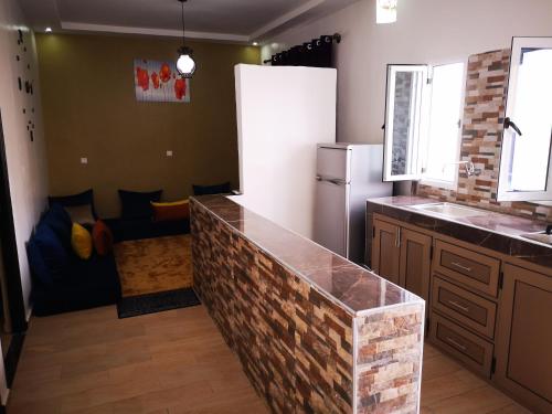 a kitchen with a brick counter top and a refrigerator at Equinox in Tan-Tan Plage