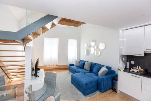 ein Wohnzimmer mit einem blauen Sofa und einem Tisch in der Unterkunft Seaside With a View - 200m away from the beach! in Cascais