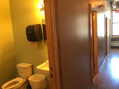 a bathroom with a toilet and a television on the wall at Hostel du Nord in Duluth
