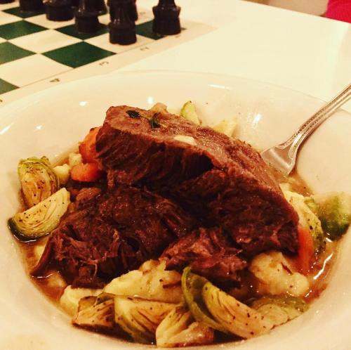a plate of food with meat and vegetables on a table at Hostel du Nord in Duluth