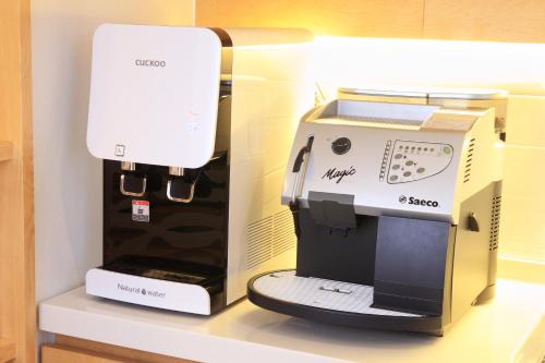 a white sewing machine sitting on a shelf next to a box at Dream House in Seoul