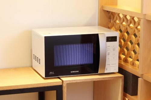 a microwave oven sitting on top of a shelf at Dream House in Seoul