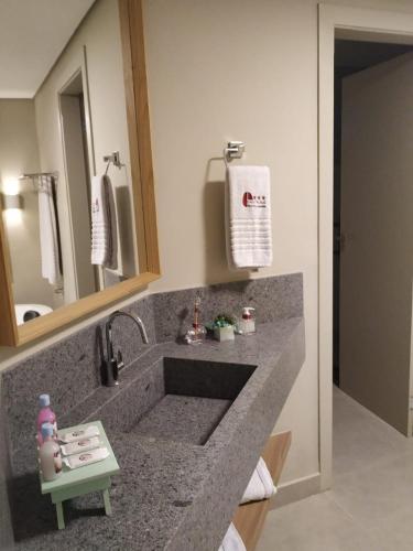 a bathroom with a sink and a mirror at Café Palace Hotel in Três Pontas