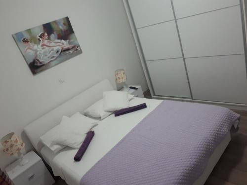 sypialnia z białym łóżkiem i fioletowym kocem w obiekcie Apartment Vedran w mieście Kaštela