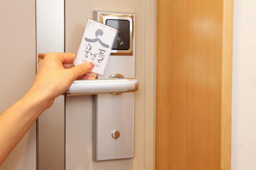 a person opening a door with a sign on it at Dream House in Seoul