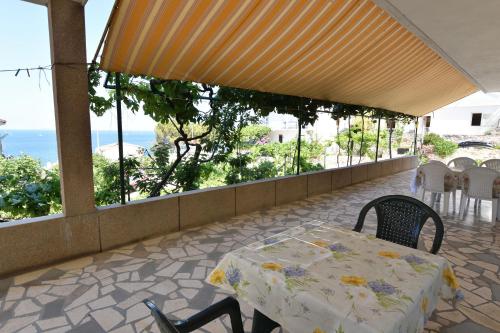 a table and chairs on a balcony with a view of the ocean at Apartments and Room Mate-Mare in Primošten