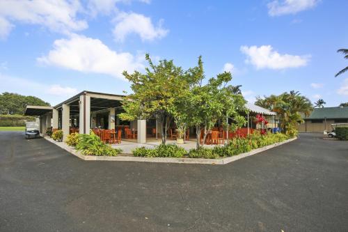 a building with chairs and trees in a parking lot at Alea Condo in Kahuku