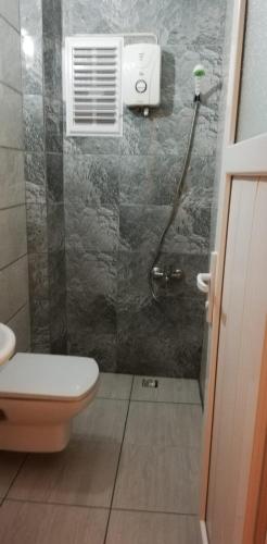 a bathroom with a shower with a toilet and a window at GökMavi Pansiyon in Bodrum City