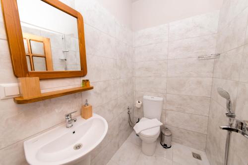a bathroom with a sink and a toilet and a mirror at Old Kalamaki Pansiyon in Kalkan