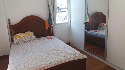a small bedroom with a bed and a mirror at 2 Suítes com Serviços in Rio de Janeiro