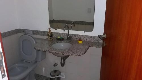 a bathroom with a sink and a toilet and a mirror at 2 Suítes com Serviços in Rio de Janeiro