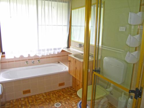 a bathroom with a tub and a toilet and a sink at WARR4C - Home Away in Myola