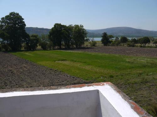 a view of a field with a concrete wall at Hotel No Que No in Tepexi del Río