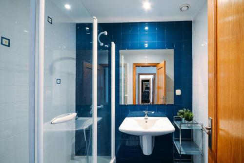 La salle de bains est pourvue d'un lavabo et d'une douche. dans l'établissement Fantastic Seaside Family Apartment with Pool, à Parede