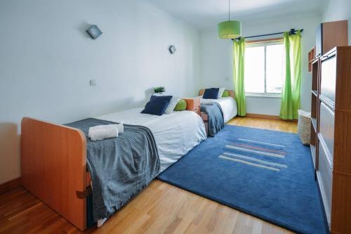 1 dormitorio con cama y alfombra azul en Fantastic Seaside Family Apartment with Pool en Parede