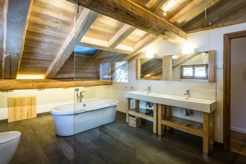 a bathroom with a tub and a sink and a toilet at Les Iles 1776 in Chamonix-Mont-Blanc