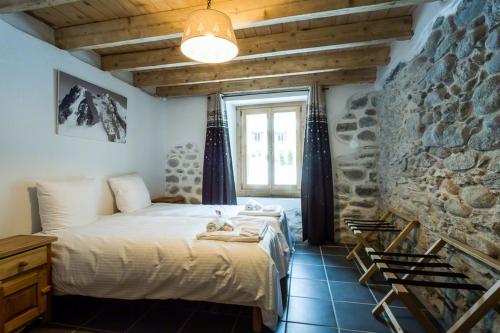 ein Schlafzimmer mit einem Bett und einer Steinmauer in der Unterkunft Les Iles 1776 in Chamonix-Mont-Blanc