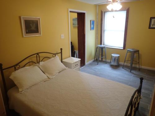 1 dormitorio con 1 cama, ventana y 2 sillas en Historic Modern Uptown Home ll en Nueva Orleans