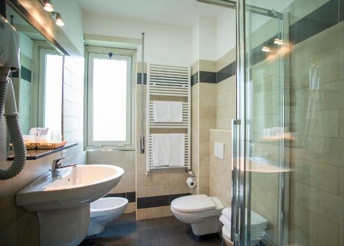 
a bathroom with a toilet, sink, and bathtub at Hotel Fiera Congressi in Milan
