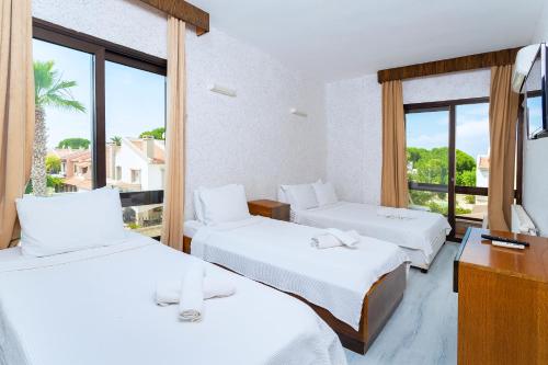 a hotel room with two beds and a window at Kabasakal Otel in Çeşme