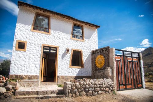 a white building with a gate in front of it at Le Foyer Colca in Yanque
