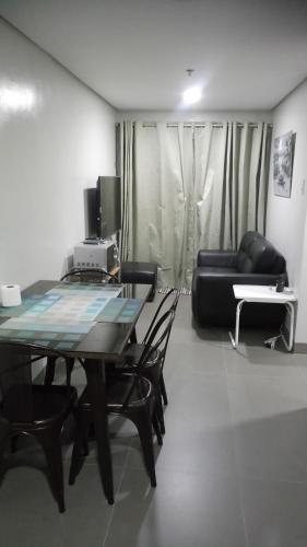 ein Wohnzimmer mit einem Tisch, Stühlen und einem Sofa in der Unterkunft Baguio Central Apartment by Goshenland in Baguio City