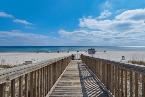 a wooden boardwalk leading to a beach with the ocean at The Palms #101 Condo in Navarre