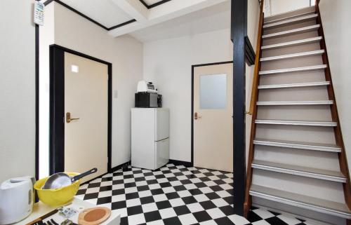 uma cozinha com uma escada e um piso em xadrez em Hakko Ichiu em Osaka
