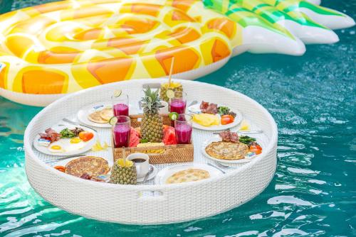 een tafel vol eten op een vlot in het water bij Villa Love Umalas in Kerobokan