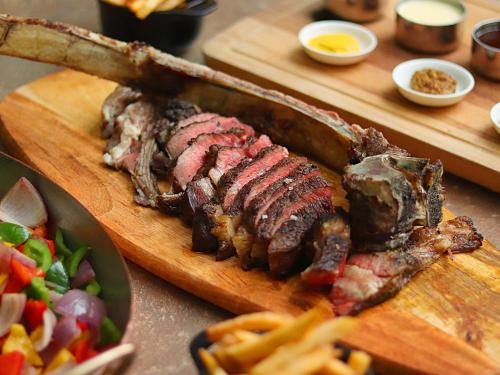 a cutting board with meat and a plate of food at Wyndham Casablanca Jakarta in Jakarta