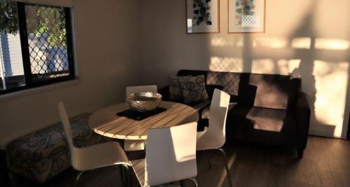 a living room with a table and chairs at NRMA Port Macquarie Breakwall Holiday Park in Port Macquarie