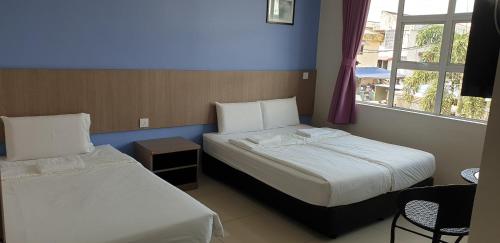 a hotel room with two beds and a window at 56 HOTEL in Mentekab