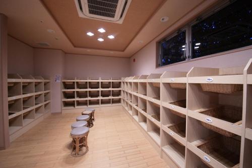 a wine cellar with empty shelves and stools at Kesennuma Plaza Hotel in Kesennuma