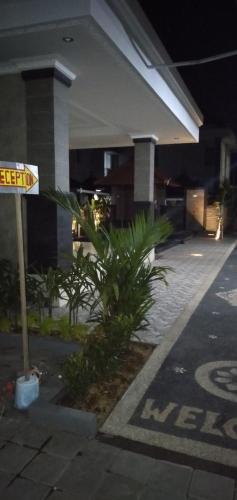 a street sign in front of a building at night at Jepun Segara Guest House in Kuta