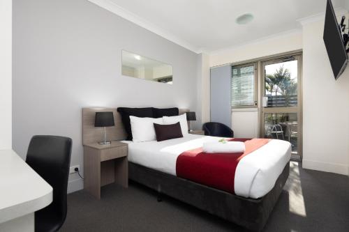 a bedroom with a large bed and a window at George Williams Hotel in Brisbane