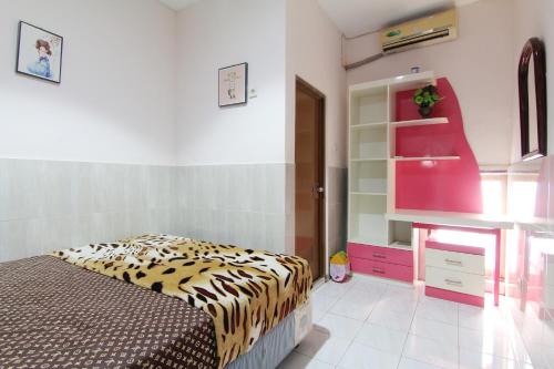 1 dormitorio con 1 cama y vestidor en una habitación en Wanderlust Homestay, en Yogyakarta