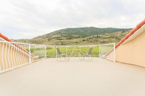 a balcony with chairs and a view of the mountains at Shiraz Villa in Osoyoos